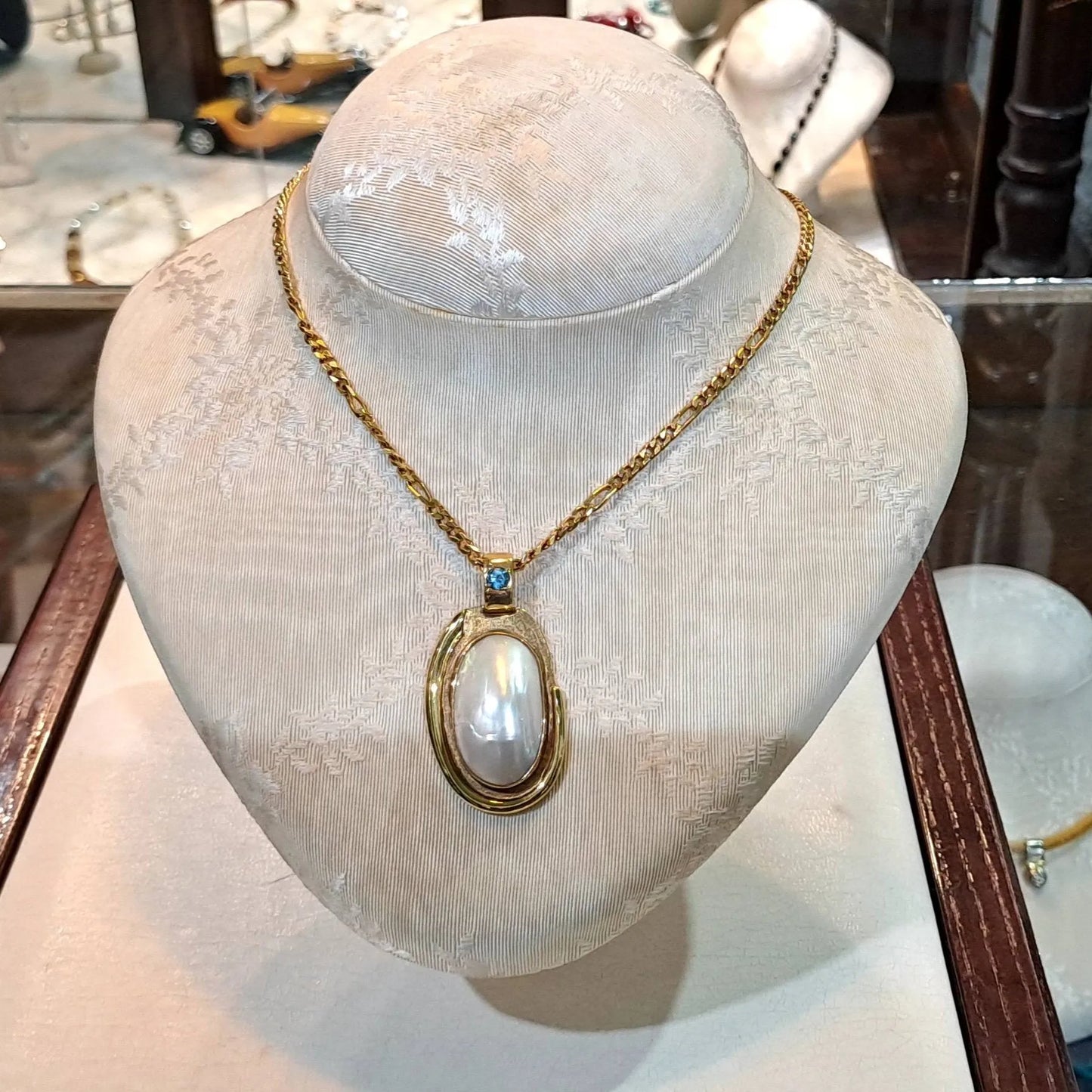 Necklace with a 18k gold medallion mother of pearl and a bleu topaz in a hand made 14k. gold chain