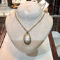 Necklace with a 18k gold medallion mother of pearl and a bleu topaz in a hand made 14k. gold chain