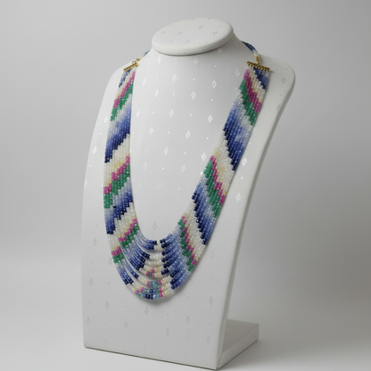 Multicolored beaded necklace on a mannequin bust against a gray background