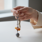 Hand holding a keychain with beads on a light surface